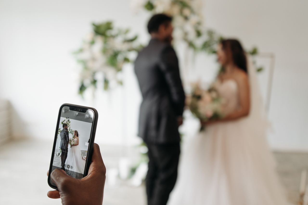 Invitați făcând poze cu telefonul la petrecere